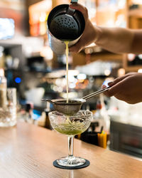 Close-up of hand pouring wine in glass