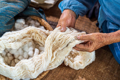 Midsection of senior woman holding wool