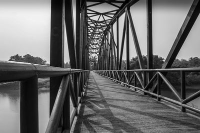 Footbridge over river against sky