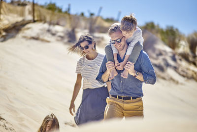 Happy family walking on the beach together