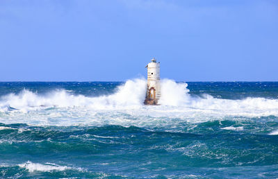 The lighthouse of the mangiabarche shrouded by the waves of a mistral wind storm
