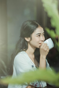 Portrait of a beautiful young woman drinking water