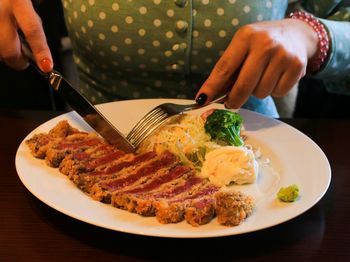 Midsection of person having food in plate