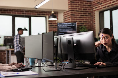 Side view of businesswoman using laptop at office