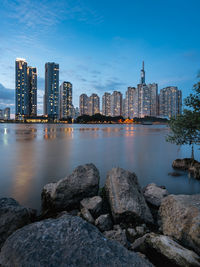 River by buildings against sky in city