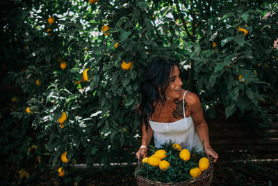 Young woman standing against orange plants