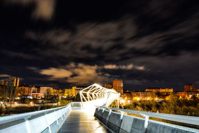 Illuminated buildings in city against sky at night