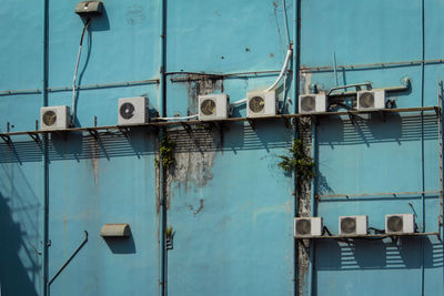 Low angle view of air conditioner compressor mounted on building