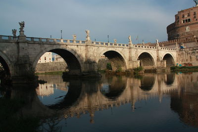 Arch bridge over water against sky