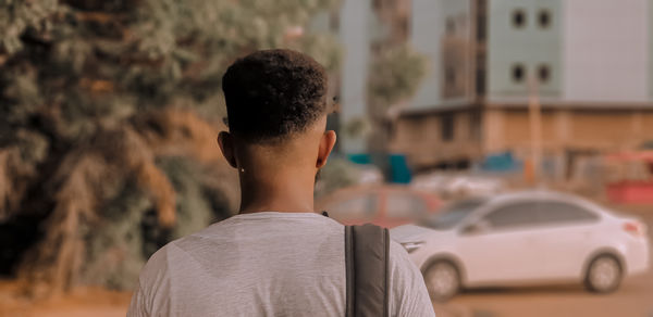 Rear view of boy standing in car