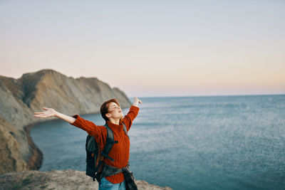 Full length of woman standing in sea against clear sky