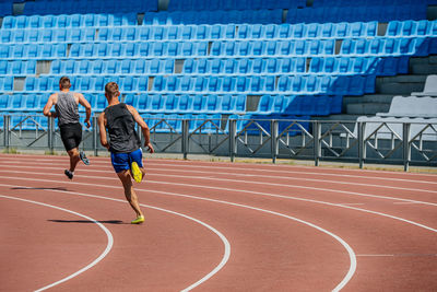 Rear view of man playing soccer at stadium