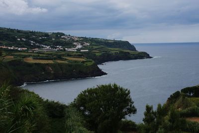 Scenic view of landscape by sea against sky