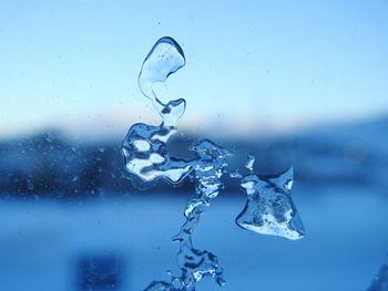 Close-up of water drop against blue background