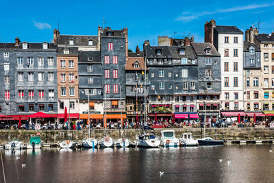 Boats moored in canal against buildings in city