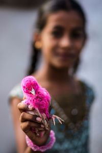 Portrait of woman holding pink flower
