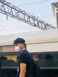 Side view of young man standing in train