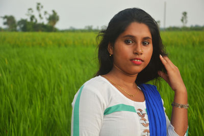 Portrait of beautiful young woman in field