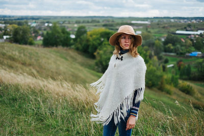 Portrait of young woman standing on field