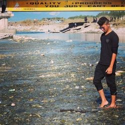 Young man standing in sewage water