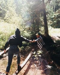 Rear view of people on rock in forest