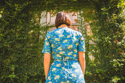 Rear view of woman standing by plants