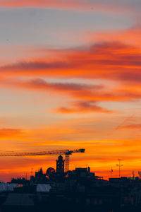 Silhouette crane against sky during sunset