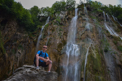 Rear view of young man looking at waterfall