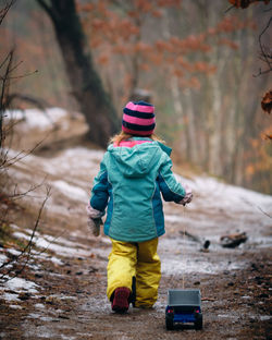 Full length rear view of child in snow