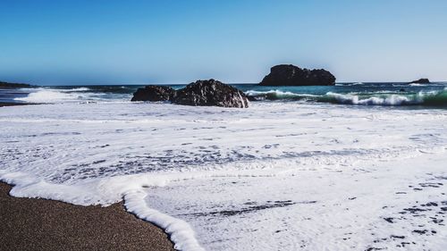 Scenic view of beach against clear sky