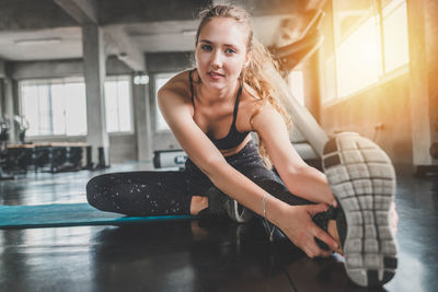 Portrait of smiling young woman sitting on floor