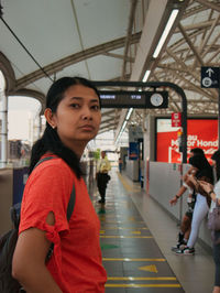 Portrait of young woman standing in city