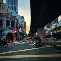 Vehicles on road against buildings in city