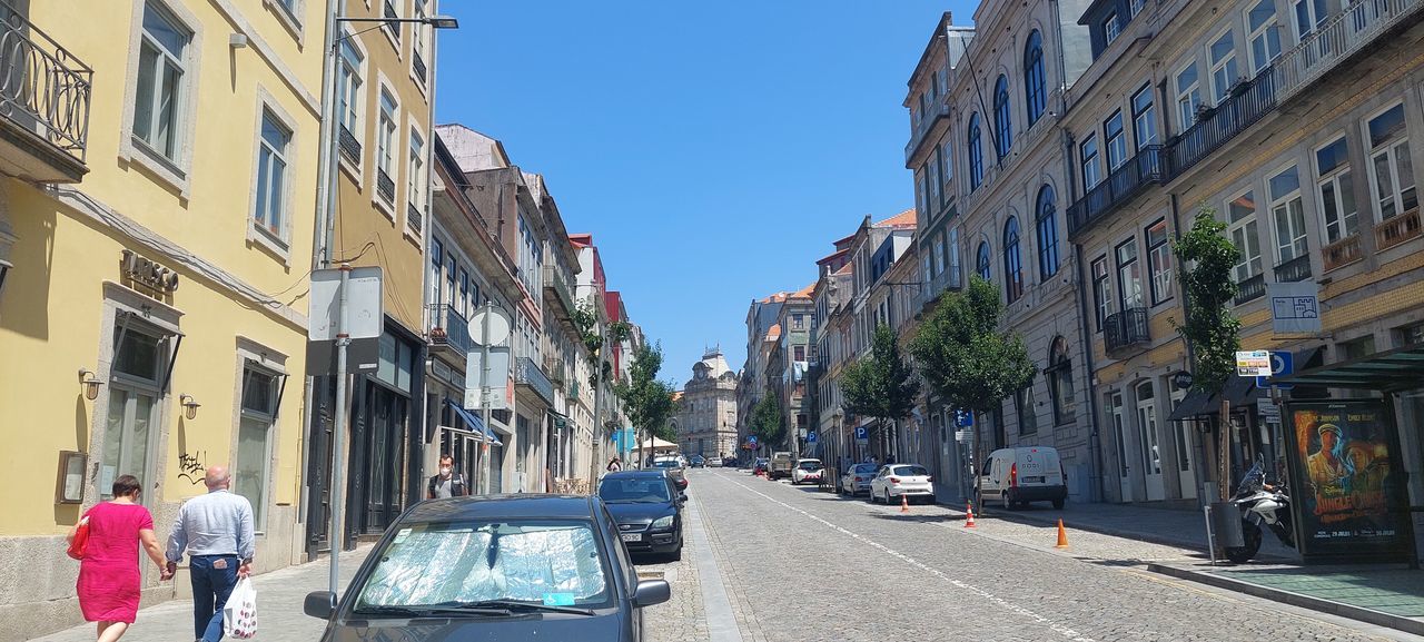 PANORAMIC VIEW OF CITY STREET AMIDST BUILDINGS