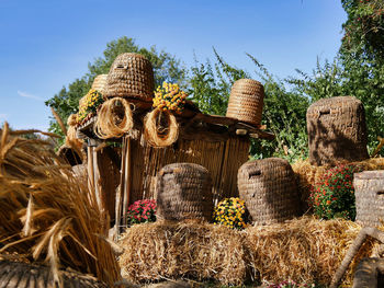 Stack of hay bales on field against sky