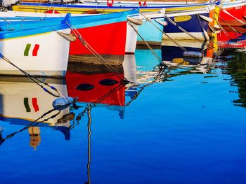 Multi colored umbrellas hanging on rope against blue sky