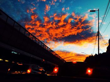 Illuminated city against sky at sunset