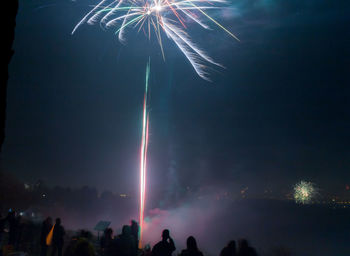 Low angle view of fireworks against sky at night