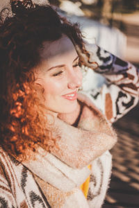 Close-up of smiling young woman in warm clothing