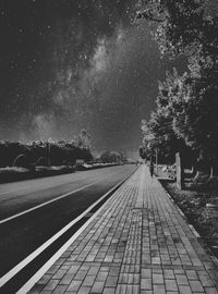 Railroad tracks against sky at night