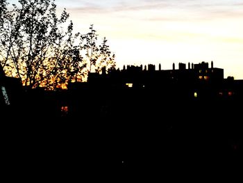 Silhouette buildings against sky at sunset