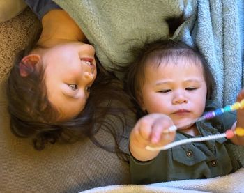 Portrait of cute baby girl lying on bed