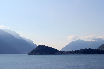 Scenic view of lake by mountains against sky