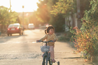 Side view of woman riding bicycle on road