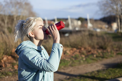 Young woman drinking water from bottle