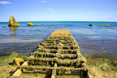 Scenic view of rocks in sea against sky