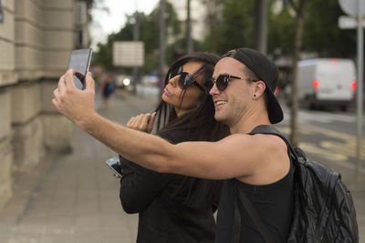 Man taking selfie with friend while standing on road