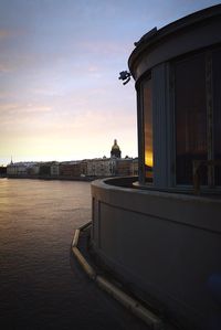 Man in city against sky during sunset