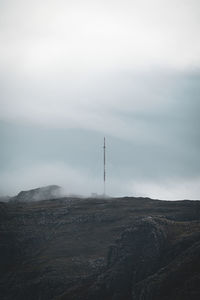 Electricity pylon on land against sky