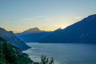 Scenic view of sea and mountains against sky during sunset